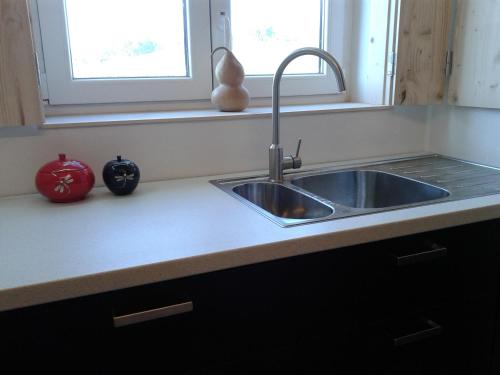 a kitchen counter with a sink and a window at Taipa 2 - Casas de Campo do Junqueirinho in Bicos