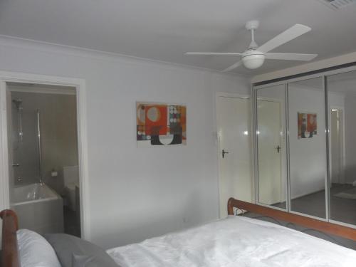 een slaapkamer met een bed en een plafondventilator bij Prime location & spacious in Adelaide