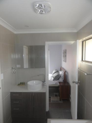 a bathroom with a sink and a tub and a bed at Prime location & spacious in Adelaide