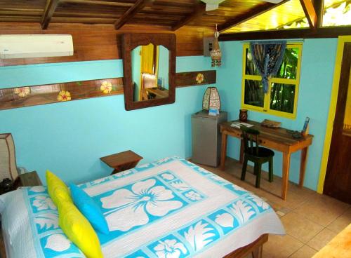 um quarto com uma cama e uma secretária. em Physis Caribbean Bed & Breakfast em Puerto Viejo