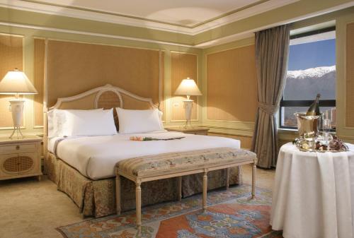 a bedroom with a bed and a table and a window at Hotel Regal Pacific Santiago in Santiago