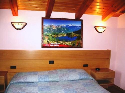 GignodにあるHotel Bellevueのベッドルーム1室(ベッド1台、壁掛けテレビ付)