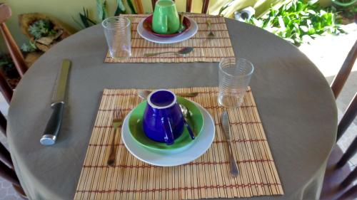 阿拉亞爾多卡博的住宿－Suíte no jardim - Praia dos Anjos，一张桌子,上面有两盘,上面有杯子