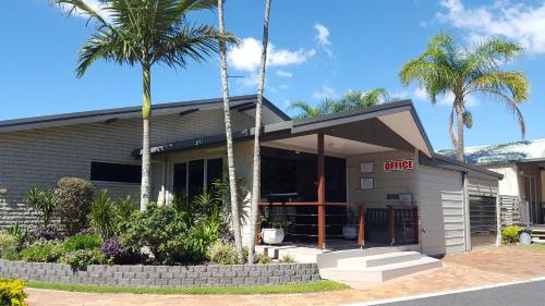 a fast food restaurant with palm trees in front of it at Colonial Tweed Holiday & Home Park in Tweed Heads