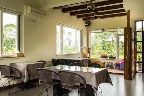 a dining room with tables and chairs and windows at ITSF B&B in Guanshan