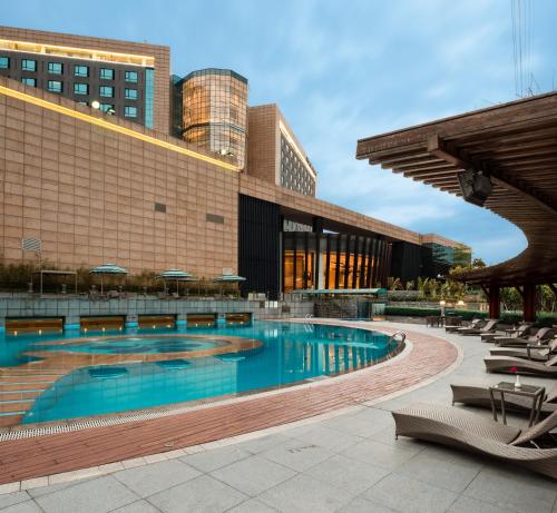 a large swimming pool in front of a building at Hotel Nikko Guangzhou - Complimentary shuttle service for concert event Baoneng&Olympic in Guangzhou