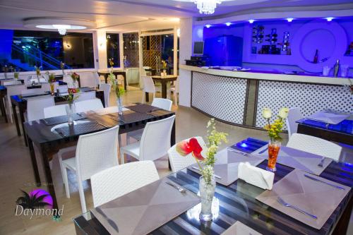 a restaurant with tables and white chairs and a bar at Daymond Blue Tropical Lodge in Santa Cruz de Barahona