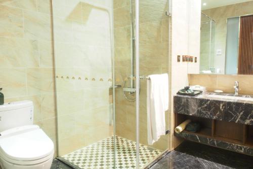 a bathroom with a shower and a toilet and a sink at Fuli Hot Spring Resort in Yuchi