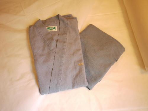 a brown shirt and tie sitting on a bed at Hotel Route-Inn Mojiko in Kitakyushu