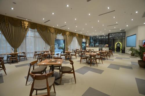 um restaurante com mesas e cadeiras num edifício em Signature International Hotel China Town em Kuala Lumpur