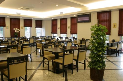 a dining room with tables and chairs and a tv at Hotel Route-Inn Mojiko in Kitakyushu