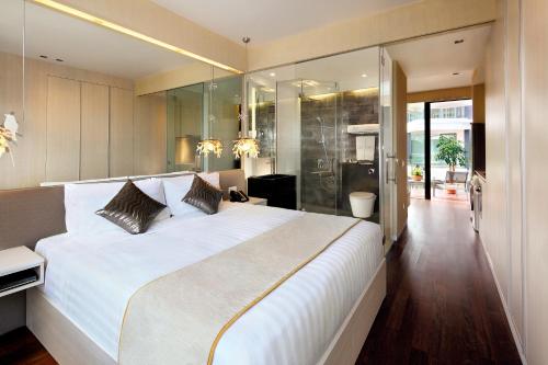 a bedroom with a large white bed and a bathroom at ST Residences Novena in Singapore