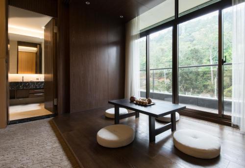 a living room with a table and two stools at Fuli Hot Spring Resort in Yuchi