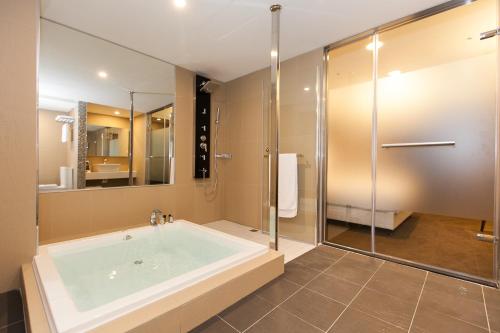 y baño grande con bañera y ducha. en Fairytale Yi Su Hotspring Hotel en Jiaoxi