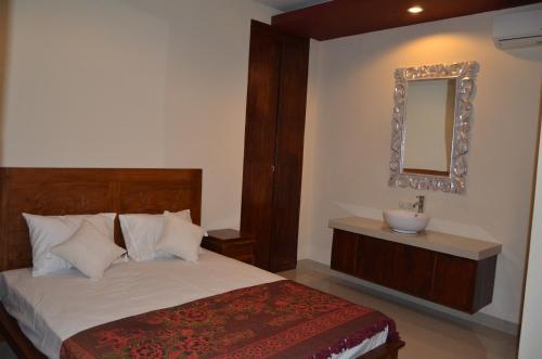 a bedroom with a bed with a sink and a mirror at Shreya Guest House in Ubud