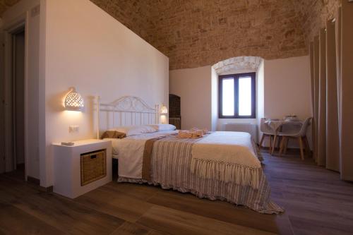 um quarto com uma cama e uma mesa num quarto em Masseria Poli Country House em Conversano