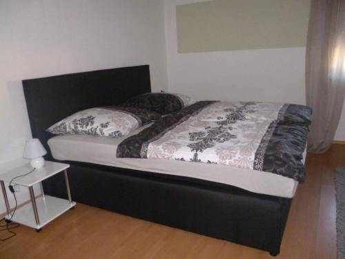 a bed with a black headboard and pillows on it at Fa Haack in Neuried