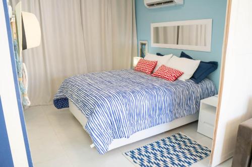 sypialnia z łóżkiem z czerwonymi poduszkami w obiekcie Apartamento Solar Água 107 w mieście Pipa