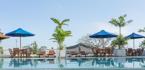 a group of chairs and umbrellas next to a swimming pool at Hotel Topaz in Kandy