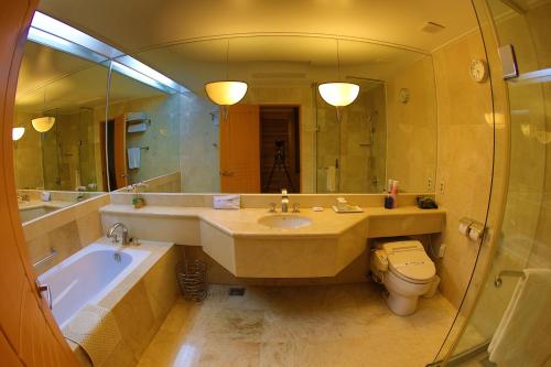 a bathroom with a sink and a tub and a toilet at Shangria Beach Tourist Hotel in Mokpo