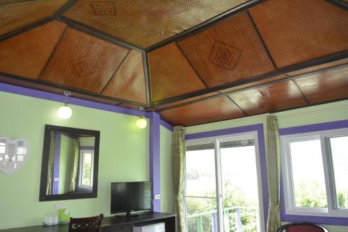 a living room with a wooden ceiling and windows at Phi Phi View Point Resort in Phi Phi Don