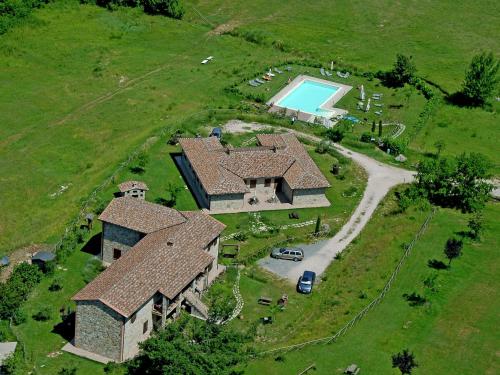 an aerial view of a house with a swimming pool at Farmhouse with small lake swimming pool private terrace garden and sheep in Passignano sul Trasimeno