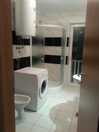 a bathroom with a washing machine and a toilet at Kartini Apartment in Nin