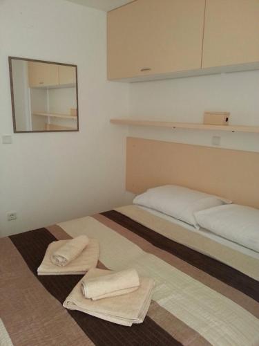 two beds in a room with towels on the floor at Kartini Apartment in Nin