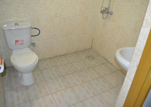 a bathroom with a toilet and a sink at Wailers Lodge in Kigali