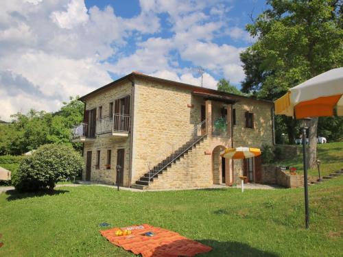 a small brick house in a yard with an umbrella at Belvilla by OYO Il Grano in Apecchio