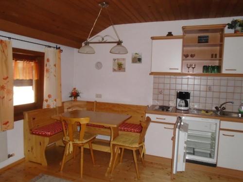 a kitchen with a table and chairs in a kitchen at Altböckhof in Schlitters