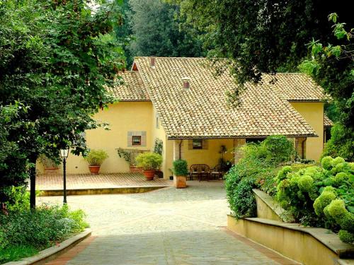una casa gialla con un patio di fronte di Belvilla by OYO Montecorneo Monolocale a Perugia