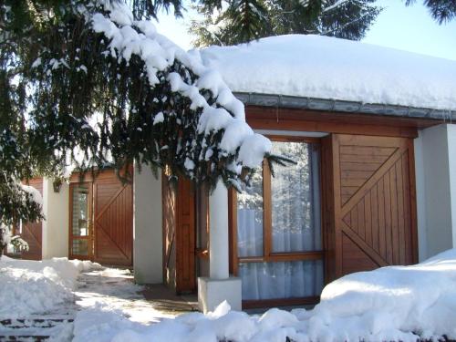 a house covered in snow with a garage at Chalet in France with Pool & Jacuzzi in Le Ménil