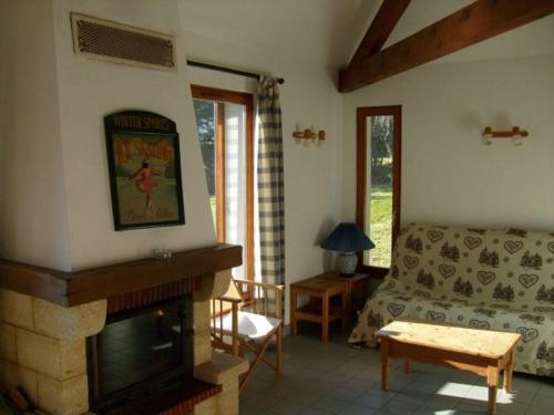 a living room with a fireplace and a couch at Chalet in France with Pool & Jacuzzi in Le Ménil