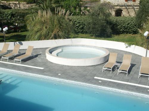 una piscina con sedie a sdraio e una piscina di Comfy Apartment in Cervione with Swimming Pool a San-Nicolao