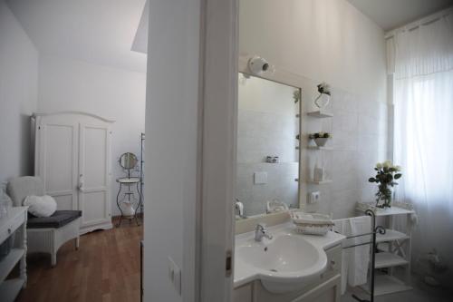 a white bathroom with a sink and a mirror at B&B La Casa di Pamela in Casciago