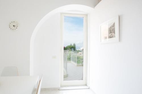 a white room with a window and a clock at Orsola Maison in Sorrento