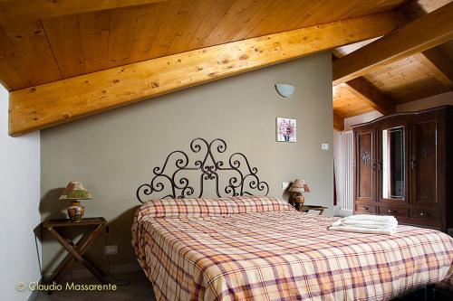 - une chambre avec un lit et une couverture en damier dans l'établissement Agriturismo Fruttirossi, à Trofarello