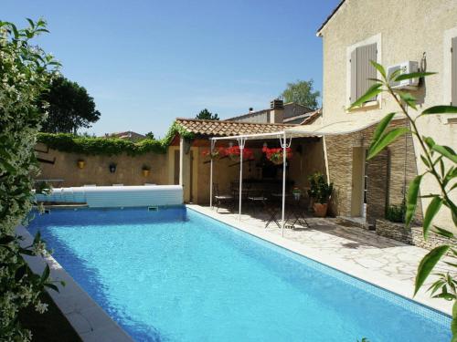 a swimming pool in front of a house at Charming holiday cottage with large private pool in Robion en Luberon