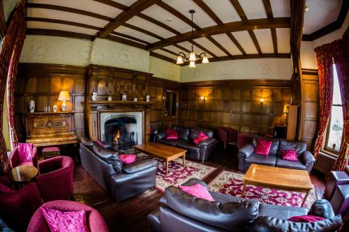 a living room with leather furniture and a fireplace at The Upper House in Stoke on Trent