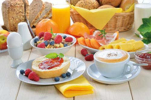 a table with breakfast foods and a cup of coffee at Erebuni Hotel Yerevan in Yerevan