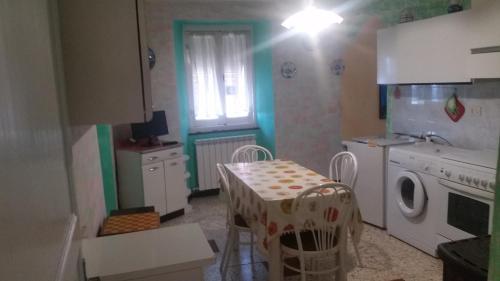 a kitchen with a table and a washing machine at B&B Il Pergolo in Carro