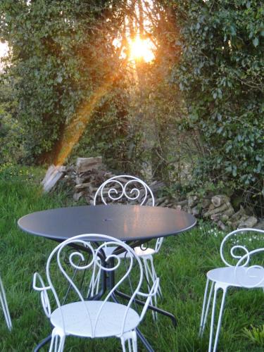 a table and two chairs in the grass at Gites de la Motte Parent in Plouguenast Langast