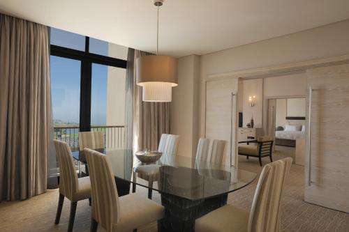 a dining room and living room with a table and chairs at Oubaai Hotel Golf & Spa in George