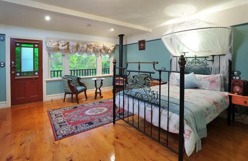 a bedroom with a large bed and a balcony at Belgrave Bed and Breakfast in Belgrave