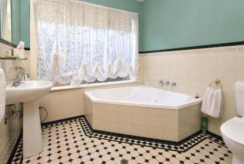 a bathroom with a tub and a sink and a toilet at Belgrave Bed and Breakfast in Belgrave