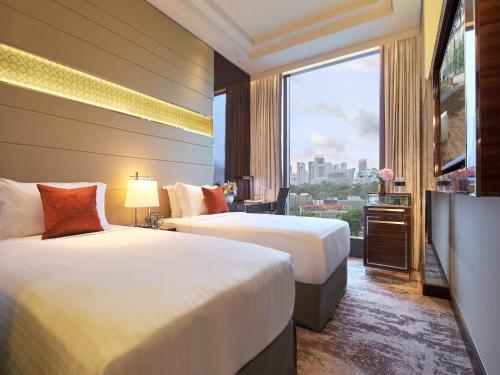 Holiday Inn Singapore Little India, an IHG Hotel في سنغافورة: غرفة فندقية بسريرين ونافذة كبيرة