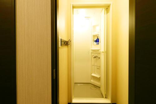 an open door to a bathroom with a white closet at Ryokan Karasawa in Kanazawa