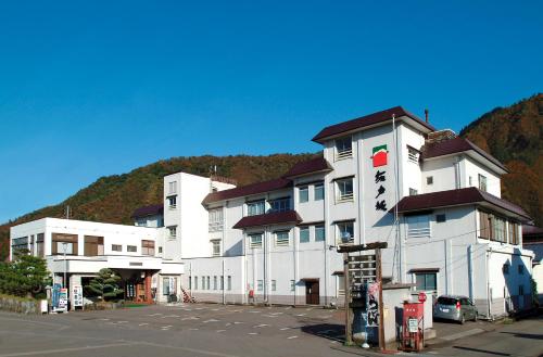 a large white building in front of a parking lot at Sakadojo in Minami Uonuma