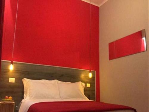 a bedroom with a red head board and a bed at Hotel Raphael in Bordighera